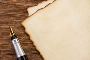 ink pen and parchment on wood