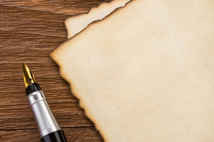 ink pen and parchment on wood